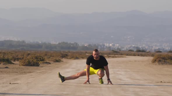 Athletic Man Warming Up and Stretching Before Workout in Nature alt