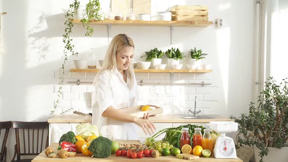 Portrait of a Happy Woman in Her Own Modern Kitchen with Lots of Fruits and Vegetables on the Table