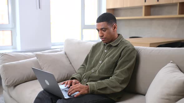 Focused Determined Young Multiracial Student or Freelancer in Casual Wear Typing on Laptop