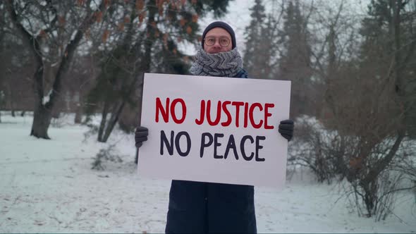 A Political activist is holding a sign No Justice No Peace in a strike action alt