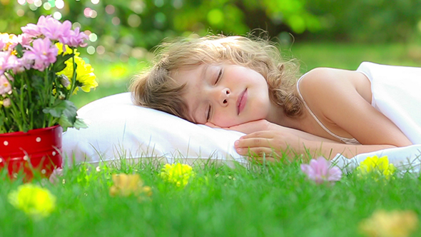 Happy Child Sleeping On Green Grass