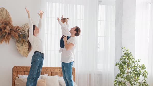 Parents Young Married Couple Caucasian Family Father Holding Little Daughter Baby Girl Lifts Up in alt
