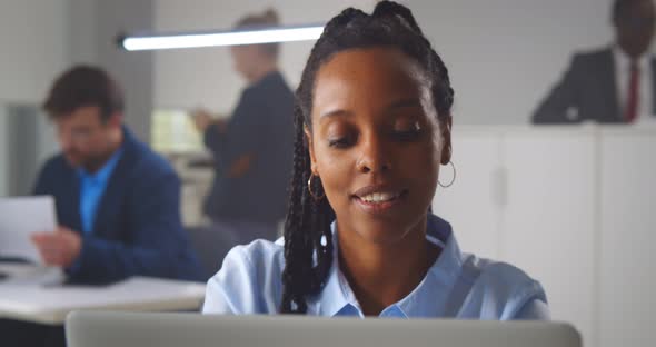 Attractive African Businesswoman Sitting at Office Table Working on Laptop alt
