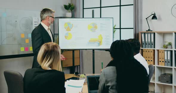 Businessman Explaining Presentation on Whiteboard About Indicators on Economic Growth alt