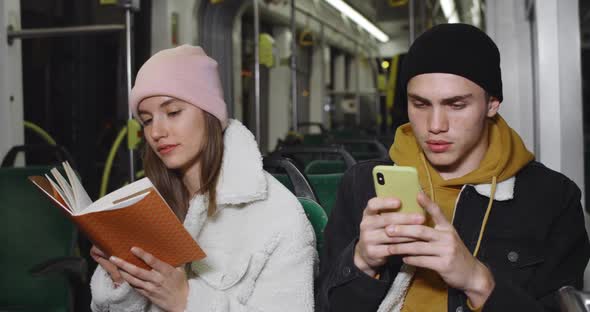 Young Handsome Guy Using His Smartphone While Sitting Near His Girlfriend. Millennial Attractive alt