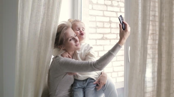 Blonde Mother And Daughter Taking Selfie