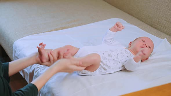 Mother Strokes and Massages Her Newborn Baby's Feet
