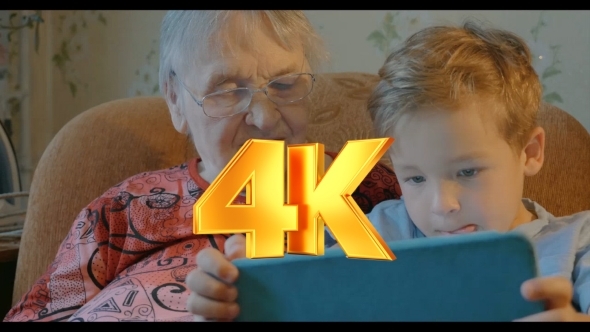 Boy Showing Something In Tablet To His Grandmother alt