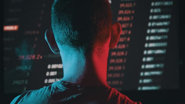 Trader Analyze Cryptocurrency Charts on a Big Screen in the Dark alt