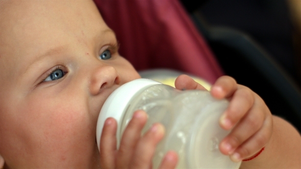 Lovely Little Girl With Blue Eyes Drinking Milk alt