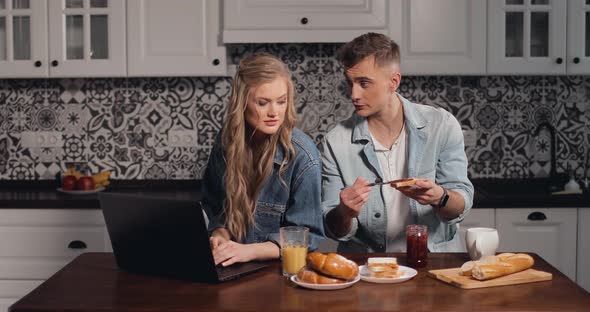 Girl Using Laptop While Couple Having Breakfast