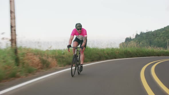 Tracking shot of a male cyclist on country road.  Fully released for commercial use.