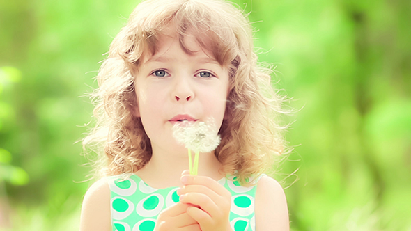 Happy Child Blowing Dandelion