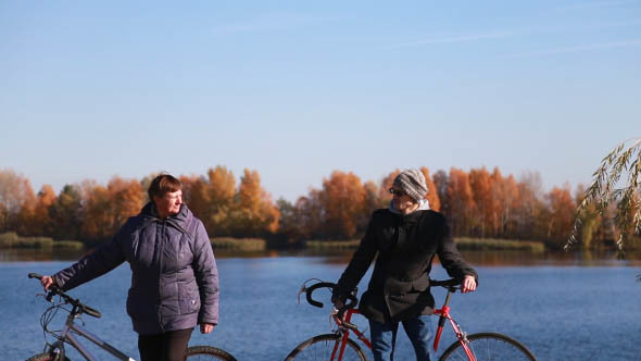 Friends Walking with Bicycles Near the River alt
