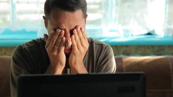 Tired Man Massaging Eyes alt