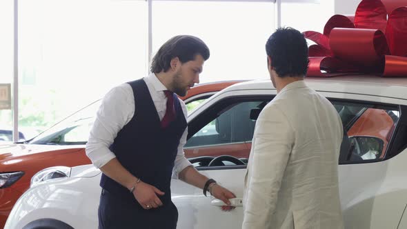 Professional Car Salesman Opening Door of a Car for His Male Customer alt