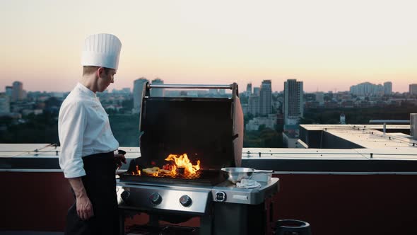 A professional Chef prepares a barbecue on the rooftop of a skyscraper. An expensive restaurant alt