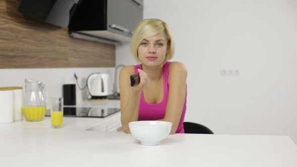 Woman Watching Serious Interesting Tv Hold Remote By Prostockstudio