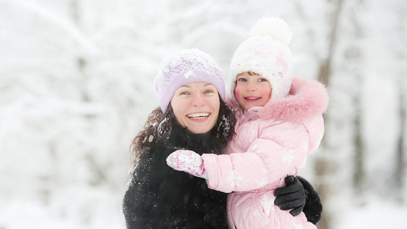 Woman And Child Playing With Snow In Winter