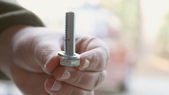Man Installing a Bolt and Washer