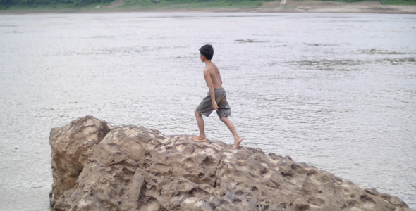 Boy Walking On Rock In A River alt