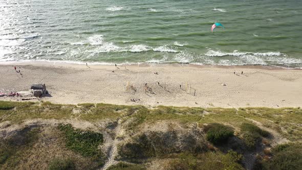 AERIAL: Flying Towards Young People Playing Football on a Sandy Beach