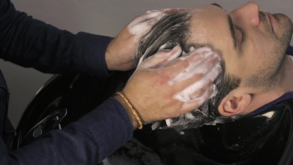 Male Hands Washing Man's Hair In Salon