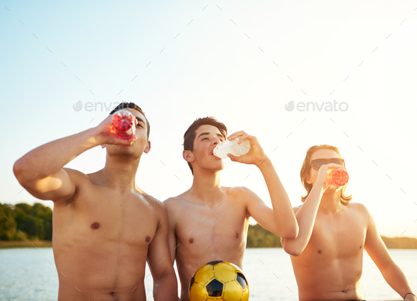 Three teenage boys enjoying a refreshing drink