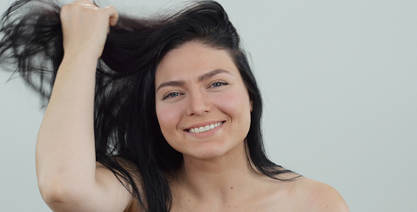 Woman Smiling and Playing with Hair