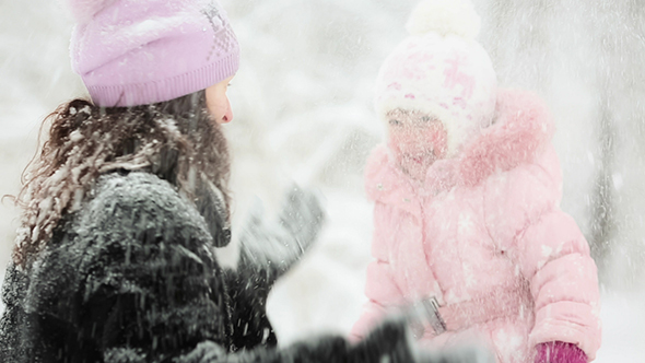 Woman And Child Playing With Snow In Winter