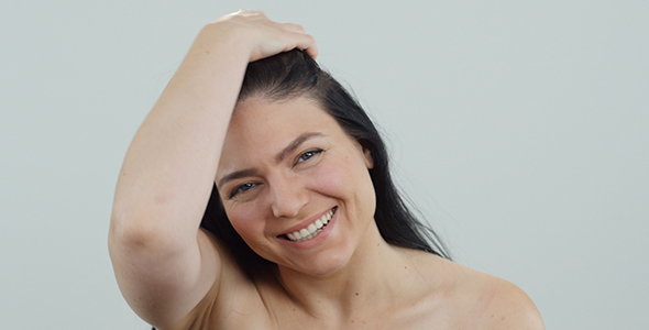 Shy Woman Smiling and Playing with Hair