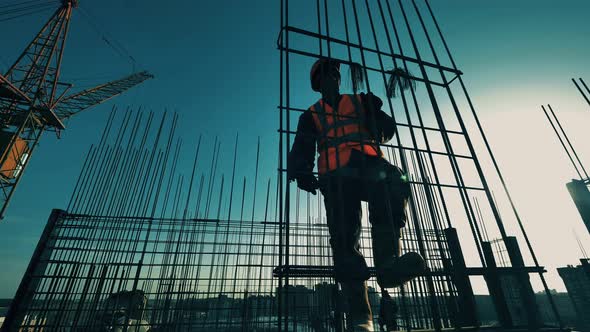 Construction Worker Is Making a Metal Framework on the Roof alt