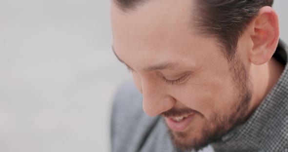 Close Up of Young Man's Face with Mustaches and a Beard Who is Smoothing the alt