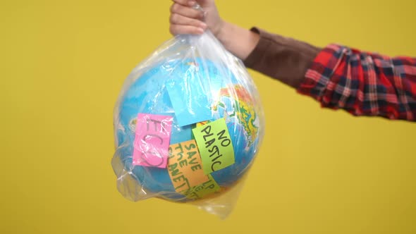 Closeup Earth Globe in Plastic Bag with Adhesive Notes Showing Ecology Problems alt