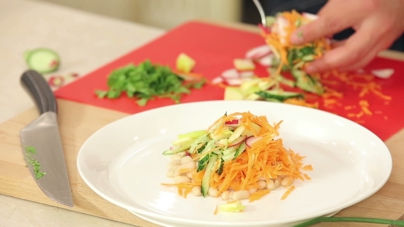 Chef Is Putting Freshly Cut Vegetables On a Plate alt