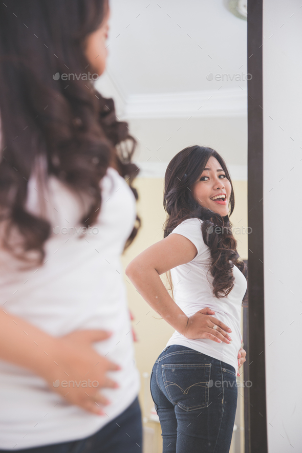 Woman looking her image on the mirror