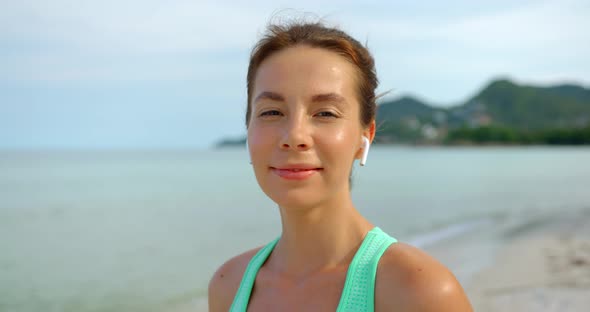 Woman Enjoys the Morning Walk After Exercise She Listening the Music Smiles to the Camera with Joy alt