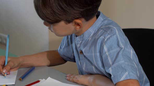 Cute Little Boy Smiling To the Camera While Drawing alt