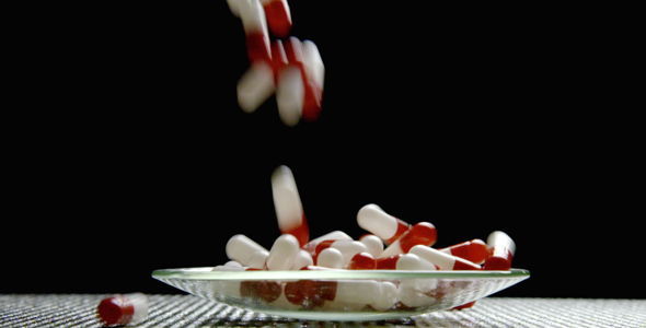 Red and White Pills Falling into Scene. 