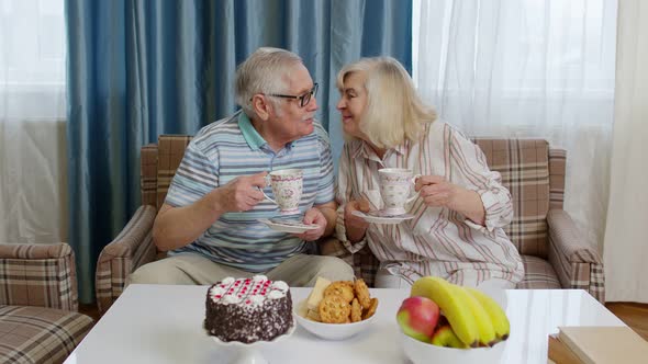 Mature Family Couple Grandfather Grandmother Relaxing on Cozy Sofa Enjoying Conversation at Home alt