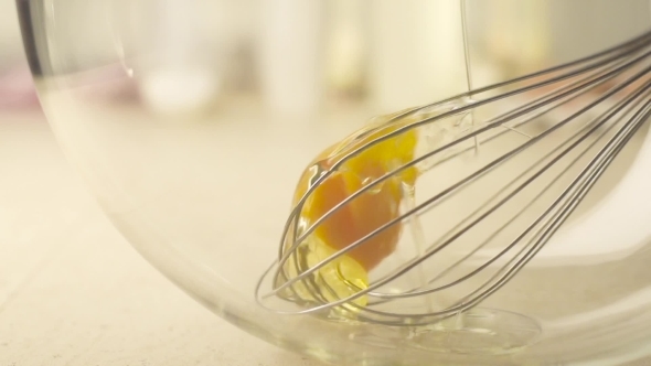 Egg Yolks And Whisk In a Glass Bowl