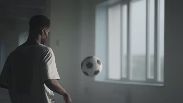 A Man Kick the Football Into a Wall in an Underground Parking Lot in the Sunlight in Slow Motion alt