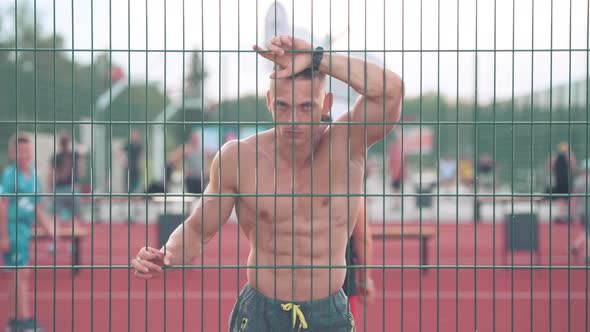athletic young man raise up his head and looking straight ahead at the basketball playground alt