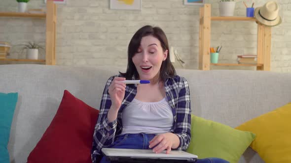 Young Joyful Woman in a Shirt with a Positive Pregnancy Test Found Out That She Was Pregnant Slow Mo alt