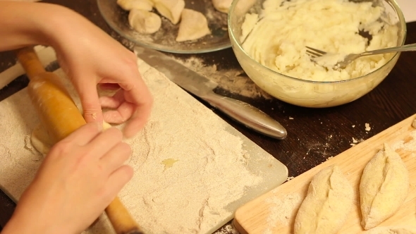 Rolling Out Dough With a Rolling Pin In Hand