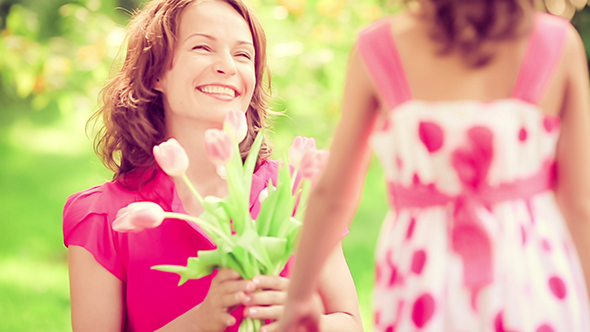 Child Giving Flowers To The Young Woman alt