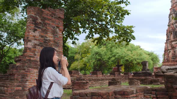 Asian woman using camera for take a picture while spending holiday trip at Ayutthaya, Thailand.