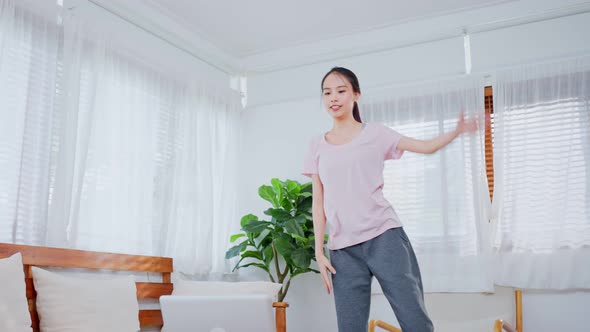 Asian Sporty young woman workout exercising by watching fitness live or video tutorial TV online. alt