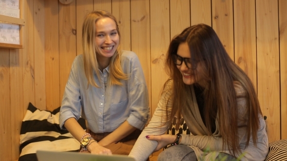 Two Beautiful Girls Smilling And Use Laptop 