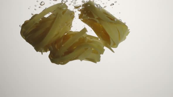 Fettuccine Pasta fall in water on white background